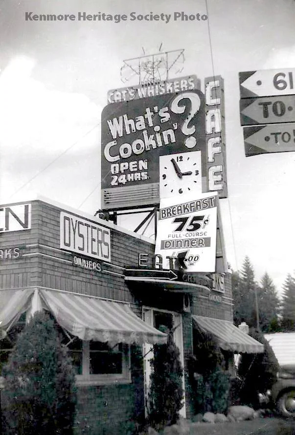 Black-and-white photograph of the Cat's Whiskers Café and its tall roadside sign in the 1930s